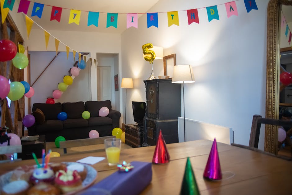 Indoor 5th birthday party setup with balloons, banners, and party hats in a cozy home setting.